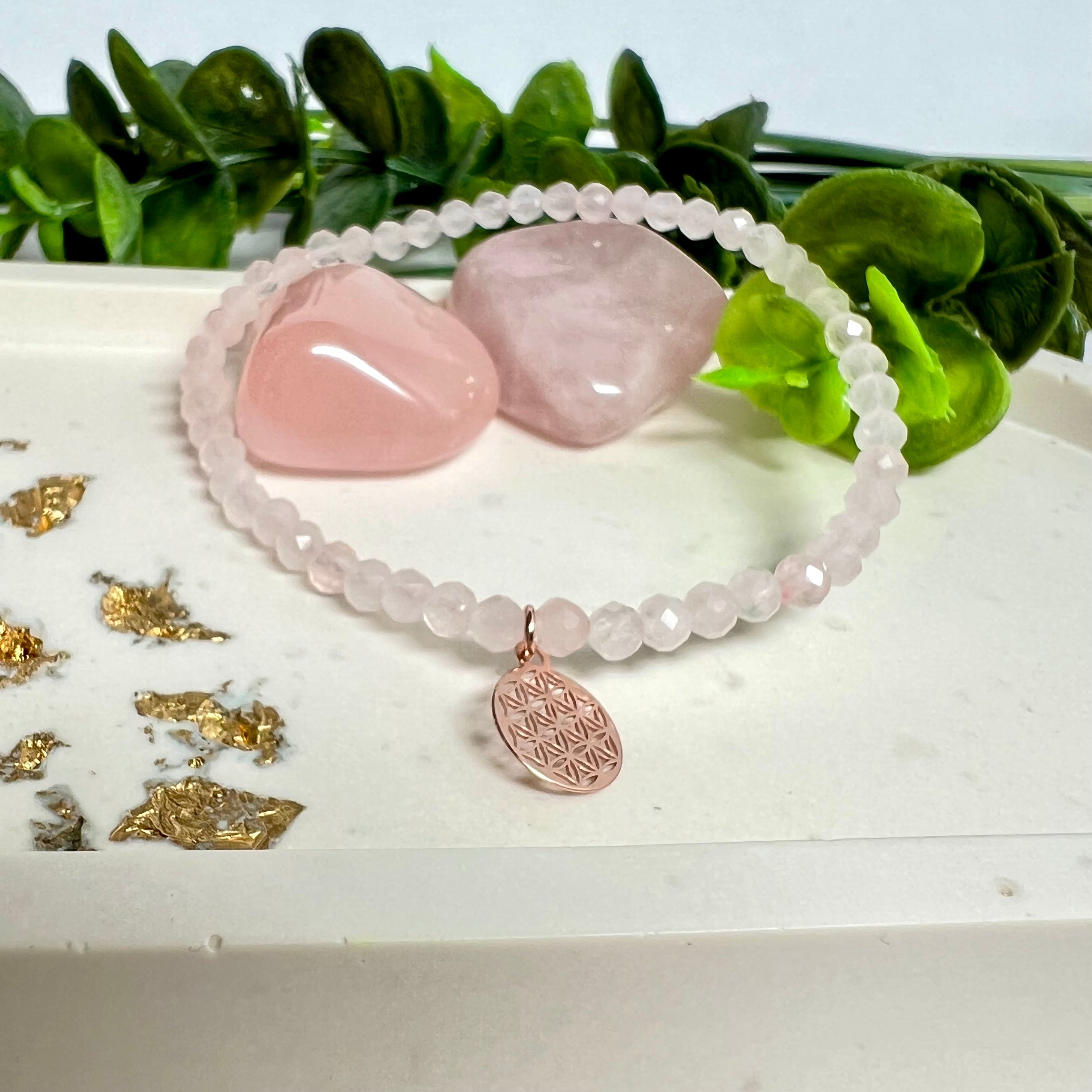 Handgefertigtes Rosenquarz-Armband mit facettierten 4 mm Perlen, ergänzt durch einen rosévergoldeten Blume des Lebens Charm aus 925er Silber. Auf elastischem Gummiband (Innendurchmesser ca. 17 cm) für bequemen Tragekomfort. Rosenquarz steht für Liebe, Harmonie und emotionale Heilung. Zartes, stilvolles Schmuckstück, ideal für den Alltag oder als besonderes Geschenk für Herzensmenschen.