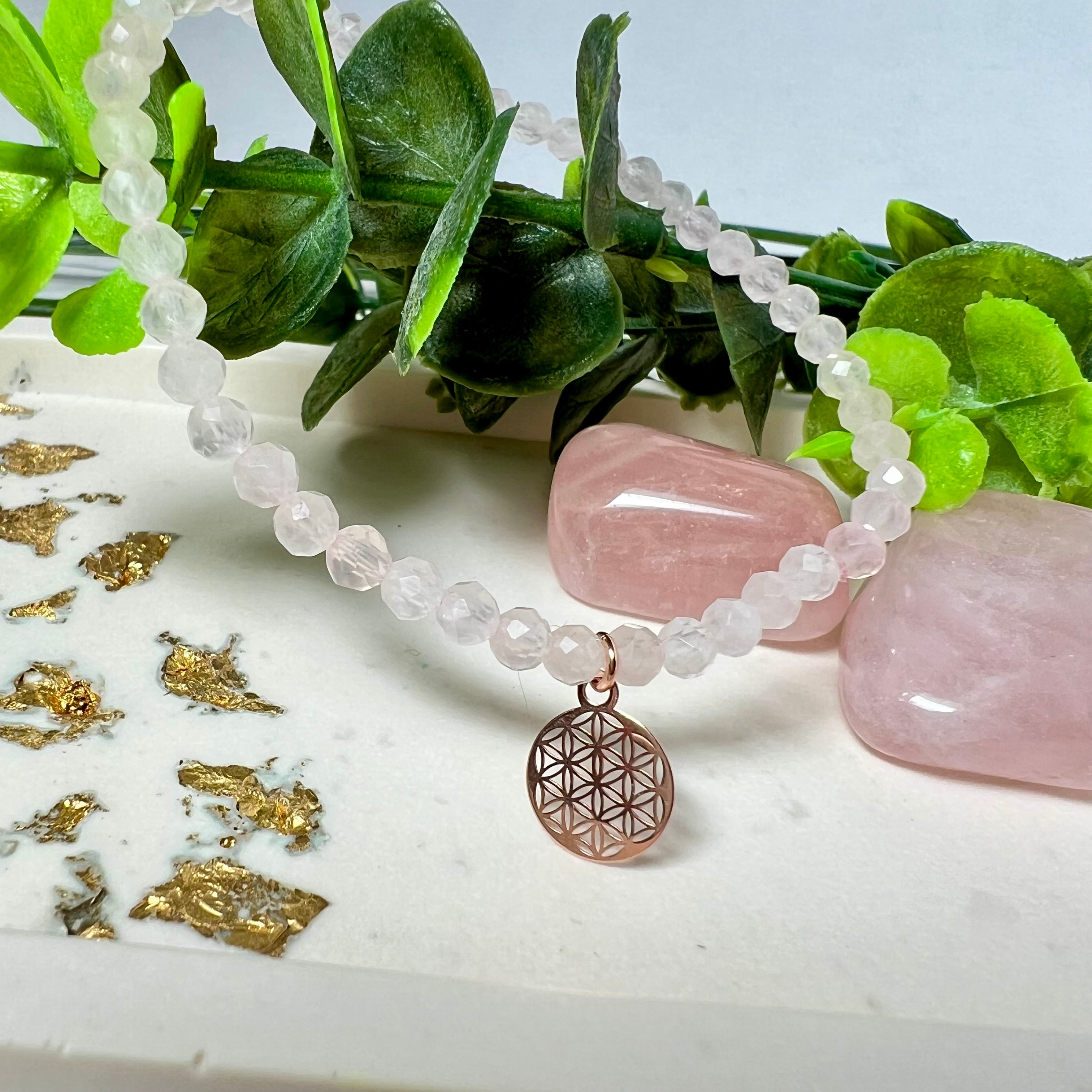 Handgefertigtes Rosenquarz-Armband mit facettierten 4 mm Perlen, ergänzt durch einen rosévergoldeten Blume des Lebens Charm aus 925er Silber. Auf elastischem Gummiband (Innendurchmesser ca. 17 cm) für bequemen Tragekomfort. Rosenquarz steht für Liebe, Harmonie und emotionale Heilung. Zartes, stilvolles Schmuckstück, ideal für den Alltag oder als besonderes Geschenk für Herzensmenschen.
