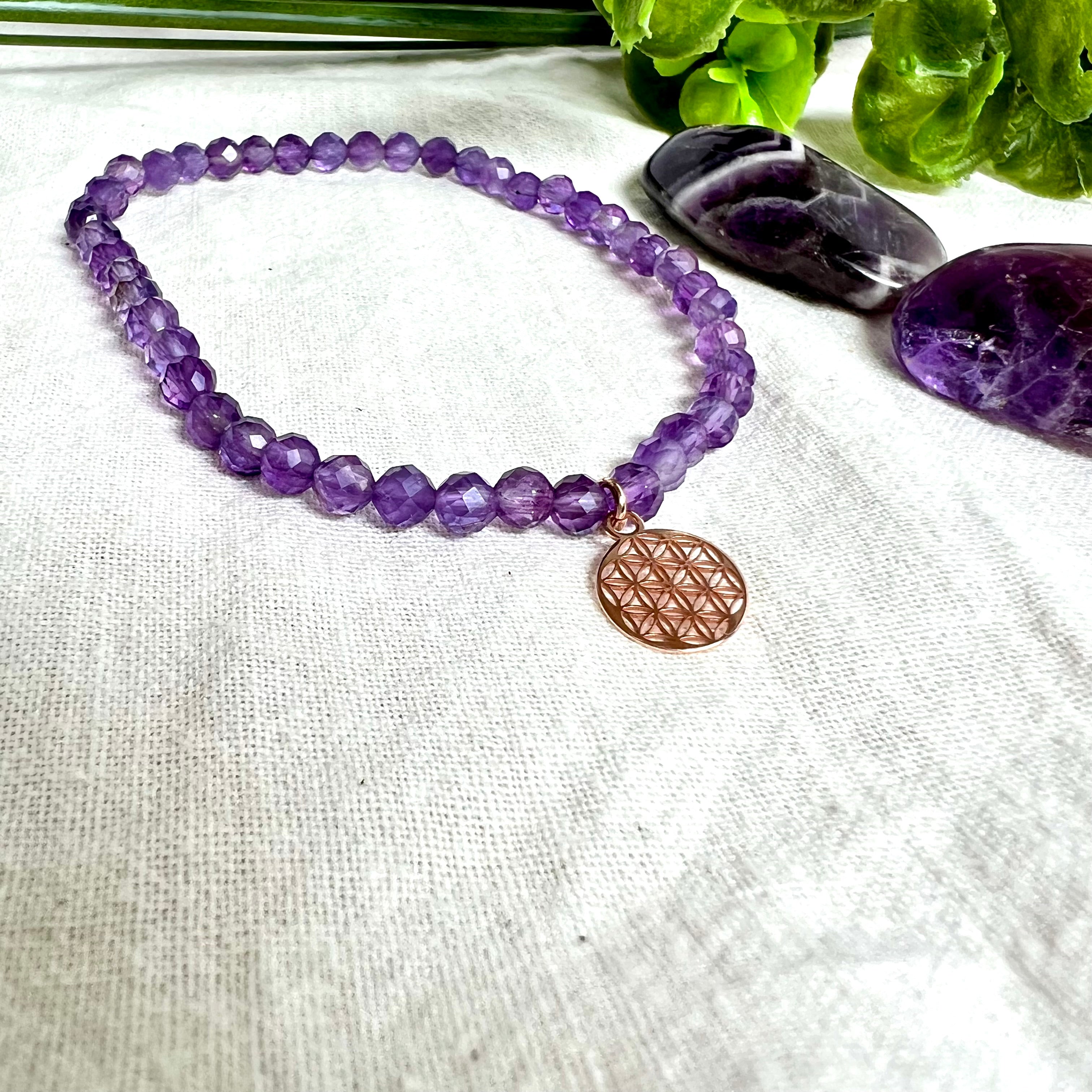 Handgefertigtes Amethyst-Armband mit facettierten 4 mm Perlen, kombiniert mit einem rosévergoldeten 925 Silber Charm in Form der Blume des Lebens. Auf elastischem Gummiband, Innendurchmesser ca. 17 cm. Edles spirituelles Design – harmonisch, zart & bedeutungsvoll. Perfekt als Geschenk oder für persönliche Achtsamkeitsmomente
