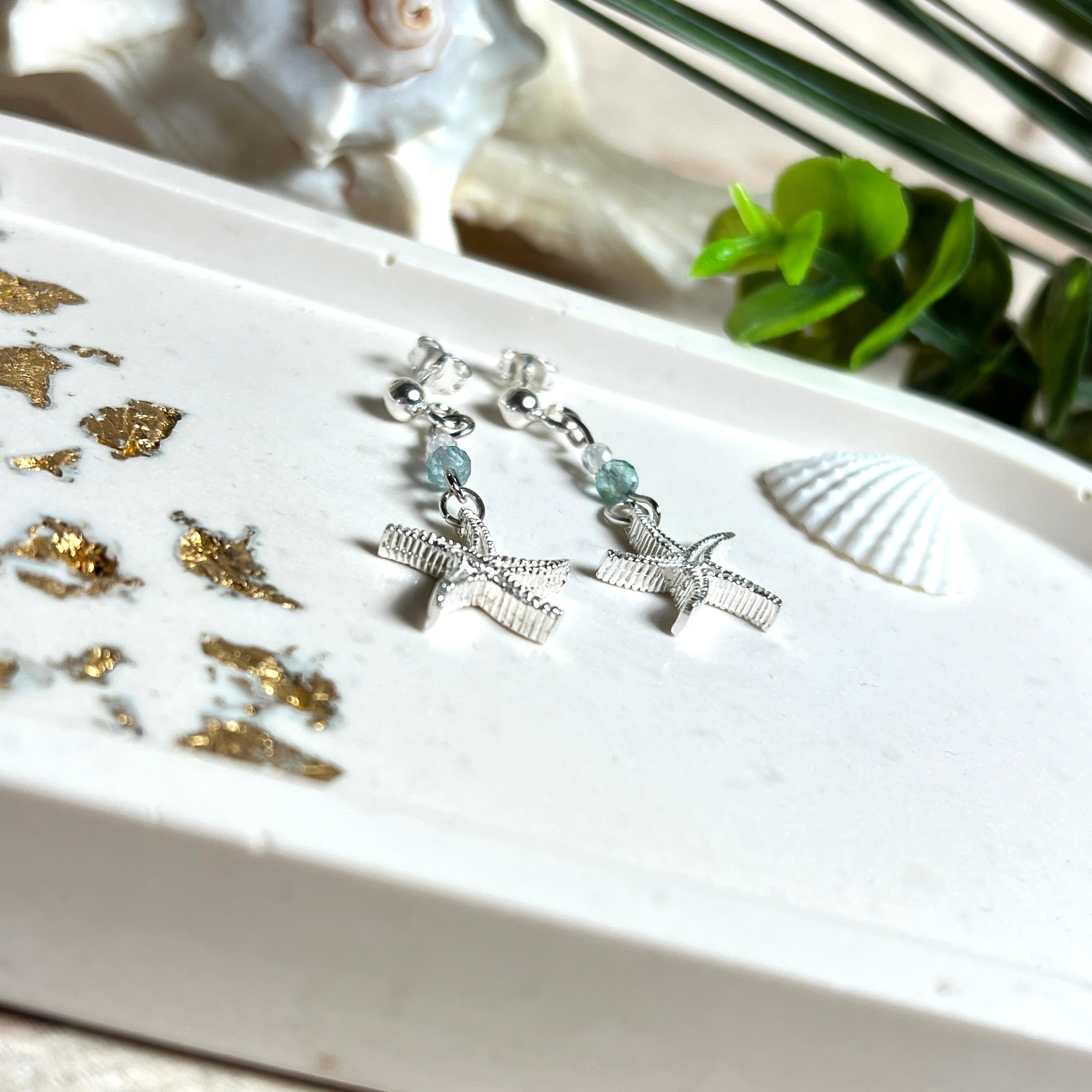 Edle „Ocean Star“ Ohrringe aus 925 Sterling Silber mit Seestern-Anhängern (18 × 17 mm), verziert mit einer aquablauen Apatitperle und funkelndem Zirkonia. Länge getragen: 45 mm. Maritime Schmuckstücke, die das Funkeln des Meeres einfangen – elegant, hochwertig und ein ideales Geschenk für Meeresliebhaber und Sommerträume.