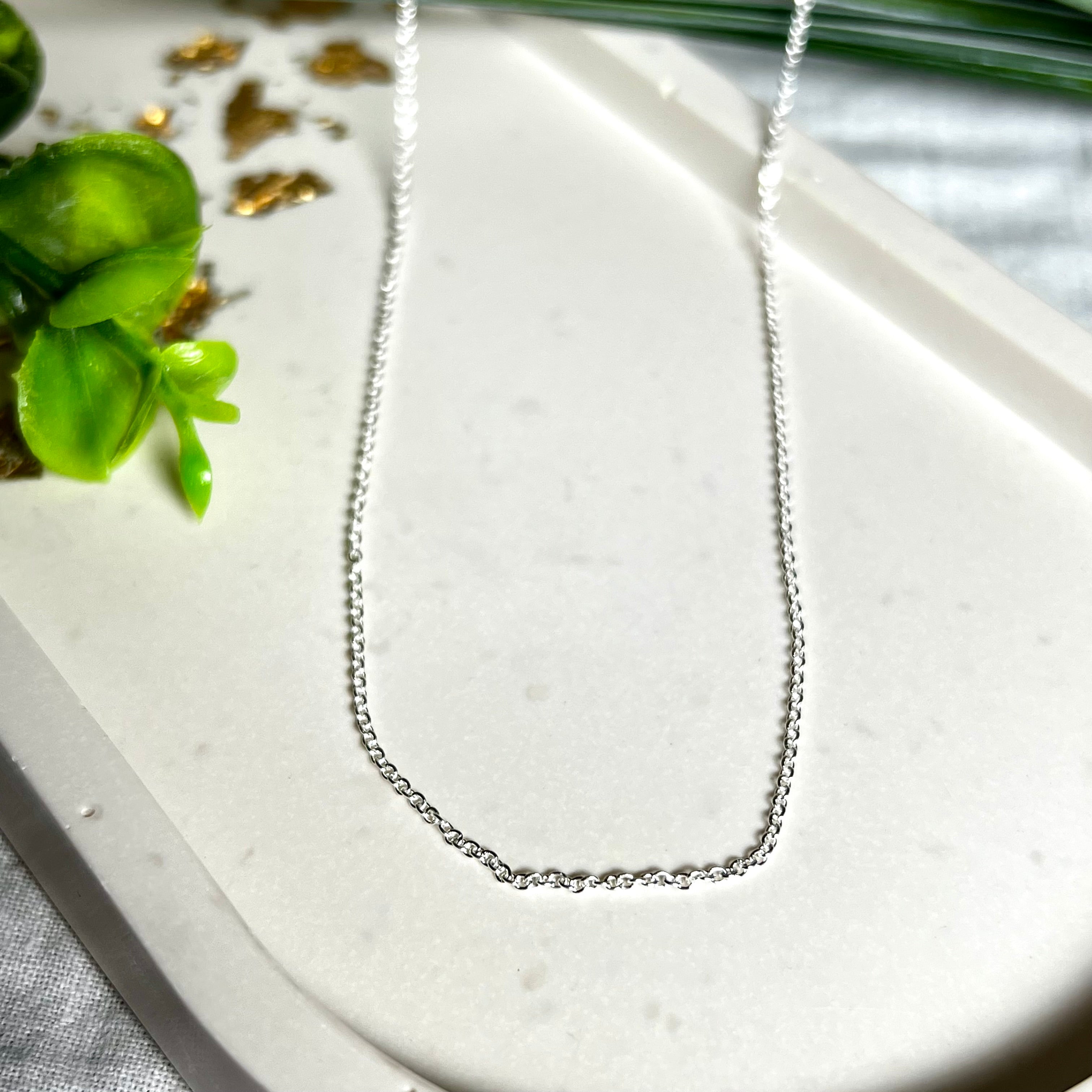 Zarte Ankerkette aus echtem 925 Silber mit klassischem Federring-Verschluss, 1 mm dick, 45 cm lang. Schlichtes, edles Design – ideal für Anhänger oder als feine Solokette. Stilvolle Schmuckfotografie mit natürlichem Hintergrund.