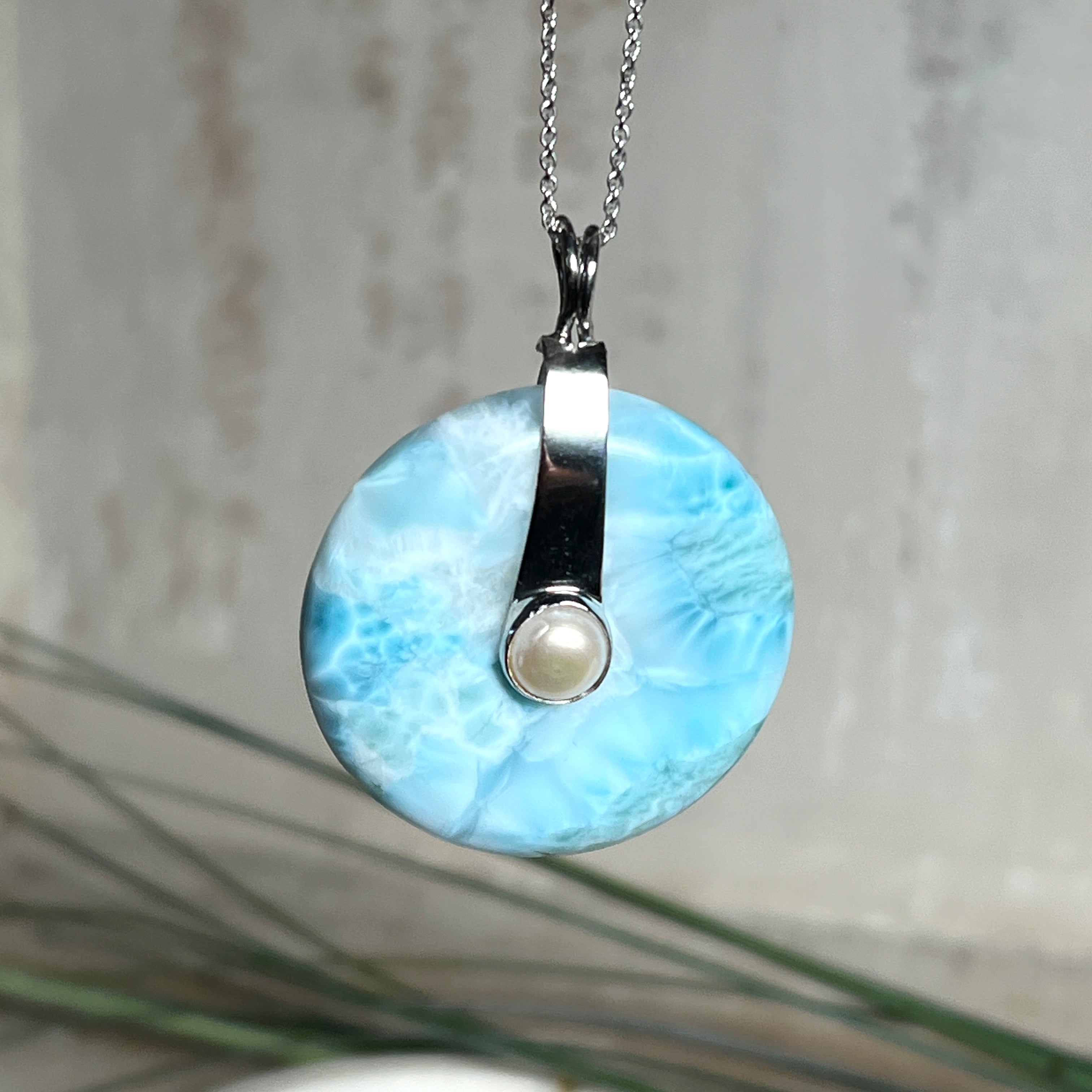 Echter Larimar-Donut (42 mm) mit Süßwasserperle, gefasst in rhodiniertem 925 Sterlingsilber. Mit 45 cm langer, rhodinierter Silberkette. Selten, edel & handgefertigt – inspiriert vom Blau der Karibik.