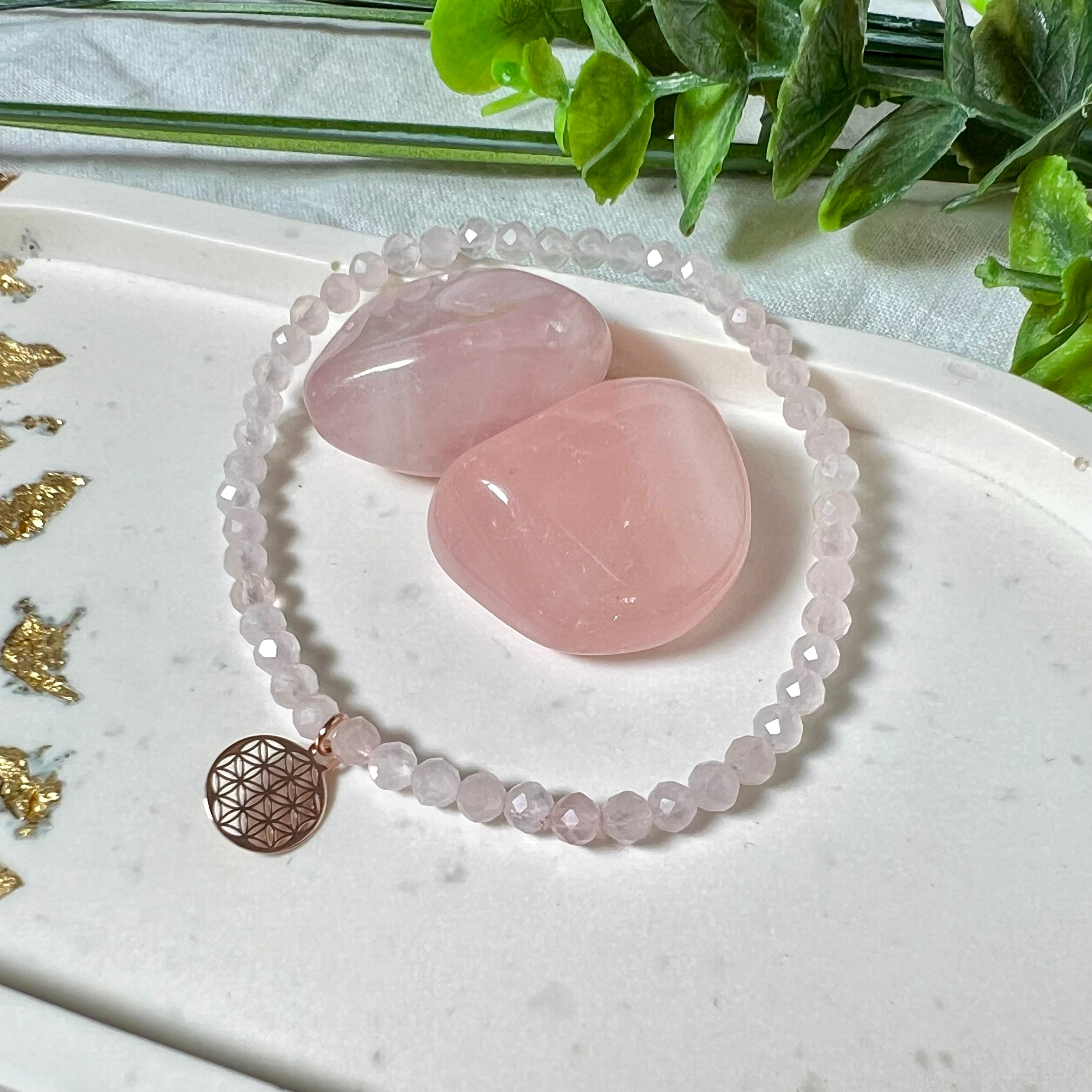Handgefertigtes Rosenquarz-Armband mit facettierten 4 mm Perlen, ergänzt durch einen rosévergoldeten Blume des Lebens Charm aus 925er Silber. Auf elastischem Gummiband (Innendurchmesser ca. 17 cm) für bequemen Tragekomfort. Rosenquarz steht für Liebe, Harmonie und emotionale Heilung. Zartes, stilvolles Schmuckstück, ideal für den Alltag oder als besonderes Geschenk für Herzensmenschen.