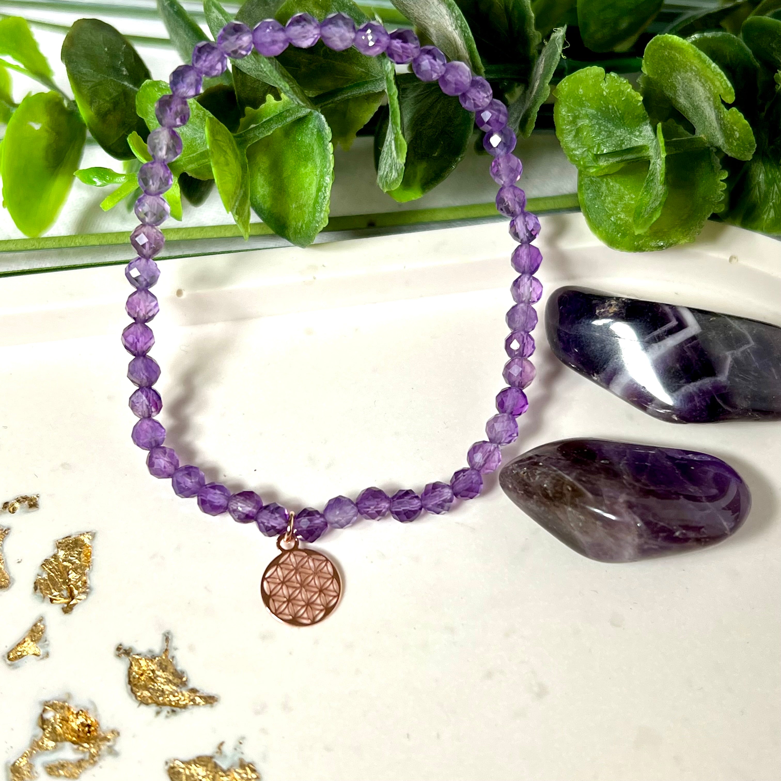 Handgefertigtes Amethyst-Armband mit facettierten 4 mm Perlen, kombiniert mit einem rosévergoldeten 925 Silber Charm in Form der Blume des Lebens. Auf elastischem Gummiband, Innendurchmesser ca. 17 cm. Edles spirituelles Design – harmonisch, zart & bedeutungsvoll. Perfekt als Geschenk oder für persönliche Achtsamkeitsmomente