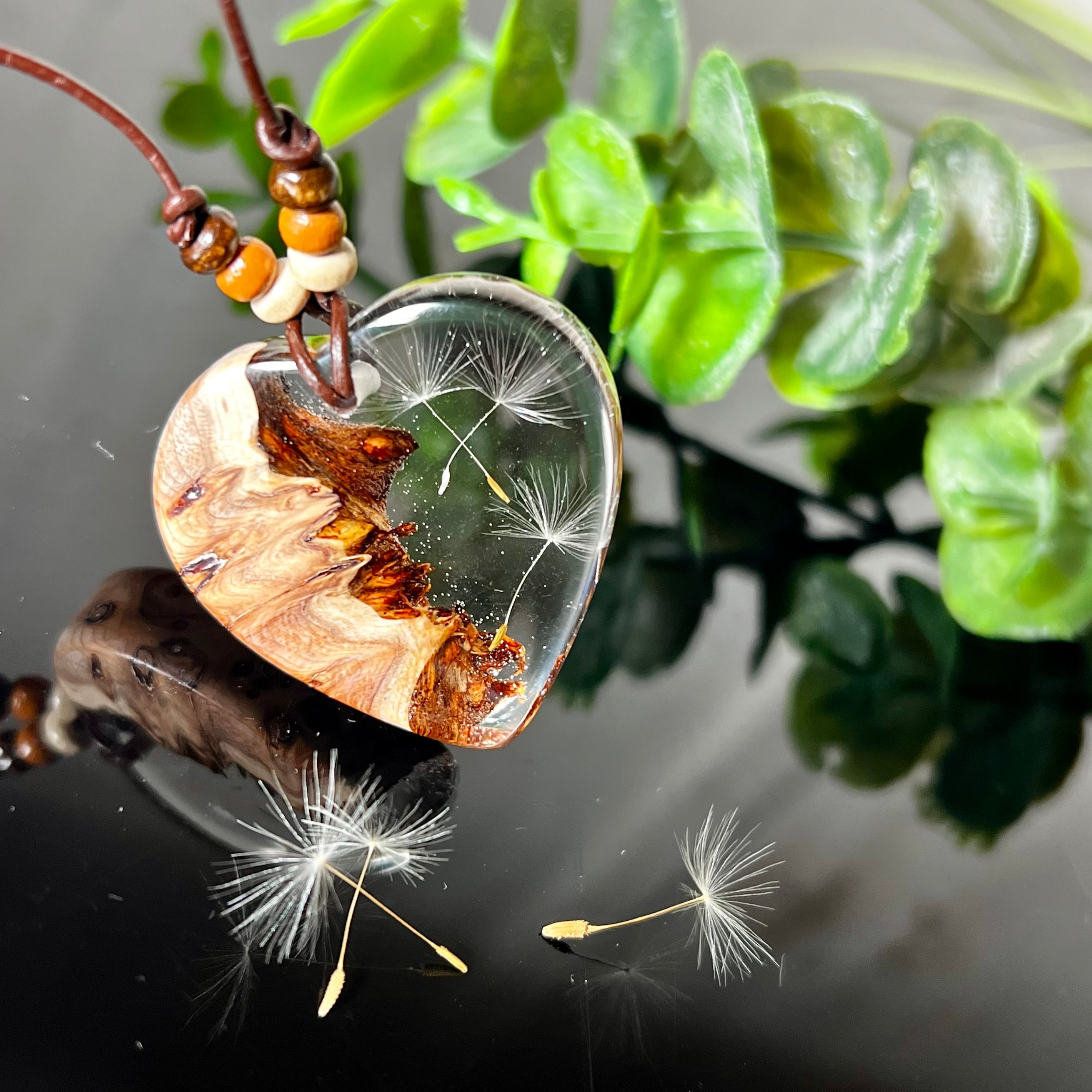 Handgefertigter Herzanhänger Pusteblumenzauber aus Maserholz und klarem Epoxidharz mit echter Pusteblume. Das Design vereint natürliche Maserstrukturen mit der Leichtigkeit schwebender Pusteblumenschirmchen – ein edles, naturverbundenes Schmuckstück mit Symbolkraft. Ideal für Naturliebhaber, Träumer und alle, die das Besondere suchen.
