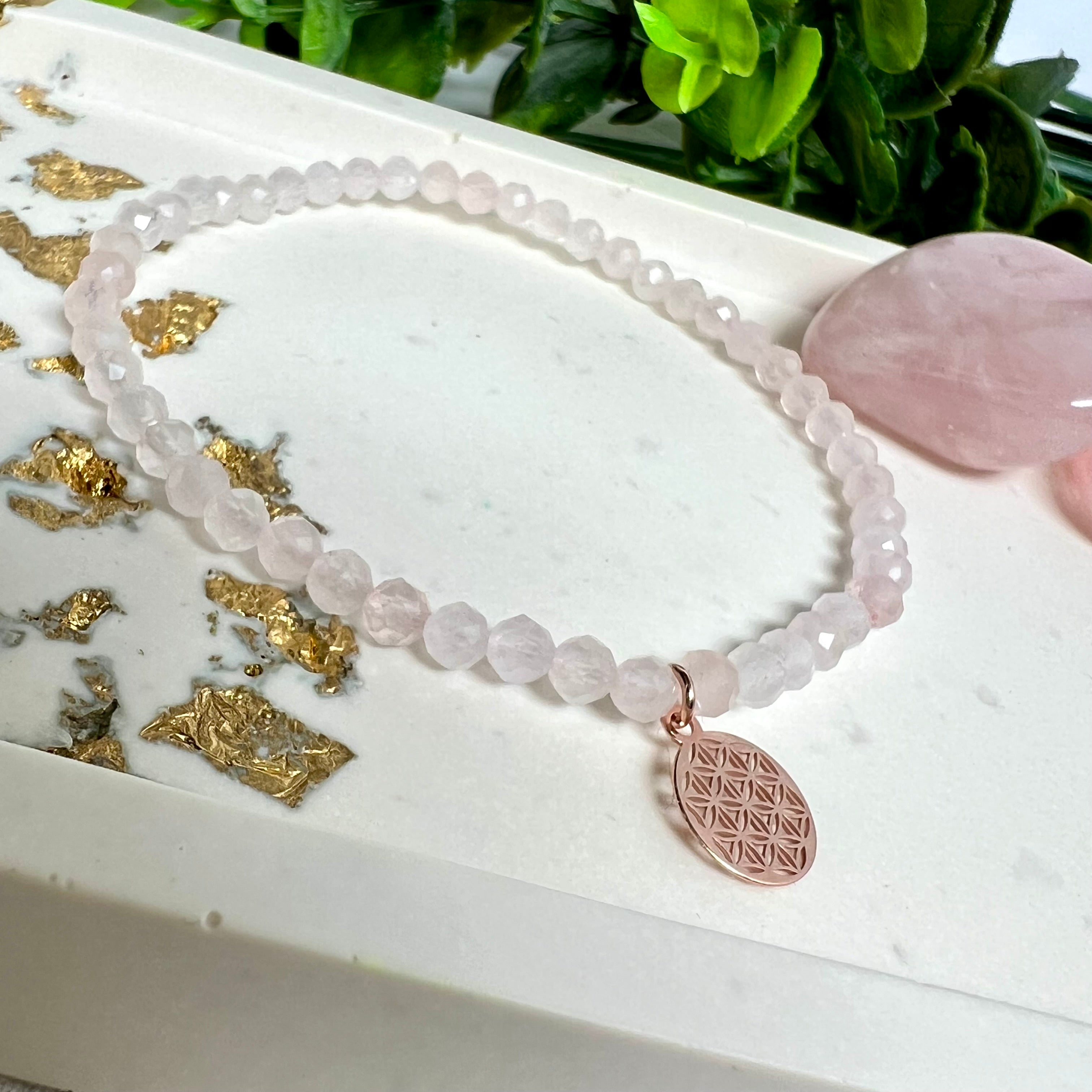 Handgefertigtes Rosenquarz-Armband mit facettierten 4 mm Perlen, ergänzt durch einen rosévergoldeten Blume des Lebens Charm aus 925er Silber. Auf elastischem Gummiband (Innendurchmesser ca. 17 cm) für bequemen Tragekomfort. Rosenquarz steht für Liebe, Harmonie und emotionale Heilung. Zartes, stilvolles Schmuckstück, ideal für den Alltag oder als besonderes Geschenk für Herzensmenschen.