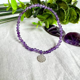 Handgefertigtes Amethyst-Armband aus facettierten 4 mm Edelstein-Perlen mit 925er Silber Charm „Blume des Lebens“. Spirituelles Schmuckstück in zartem Violett. Auf elastischem Gummiband, ca. 17 cm Innendurchmesser. Edles, fein gearbeitetes Design – ideal als Geschenk oder zur eigenen spirituellen Unterstützung.