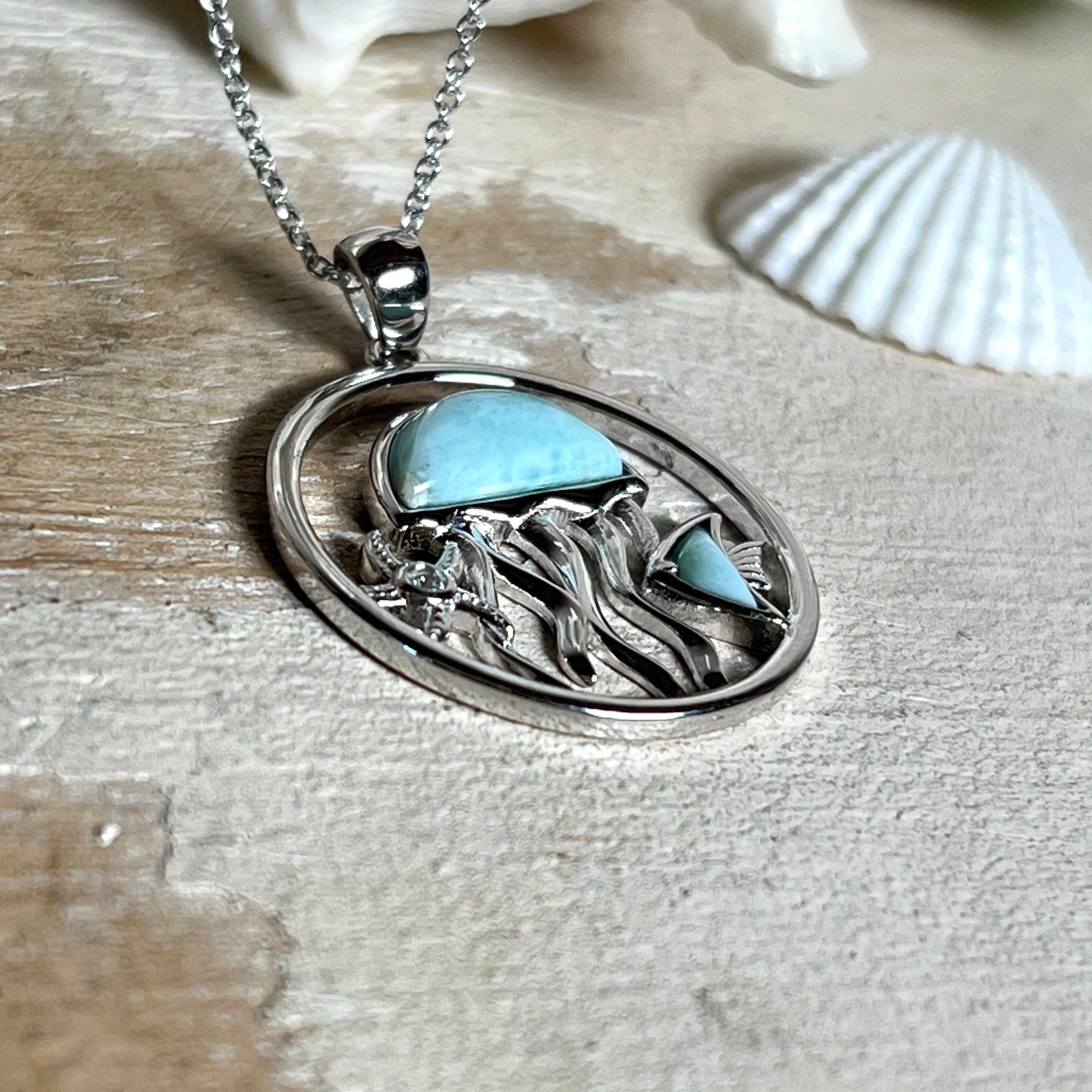 „Sealife“ – runder Anhänger aus rhodiniertem 925 Sterling Silber mit seltenem Larimar und funkelndem Topas. Das maritime Design zeigt eine Qualle, einen Fisch und einen Seestern. Anhängergröße ca. 32 × 26 mm, inklusive 45 cm langer Silberkette (1 mm Stärke). Symbol für die Schönheit und Vielfalt des Ozeans – jedes Stück ein Unikat durch das natürliche Farbspiel des Larimars.