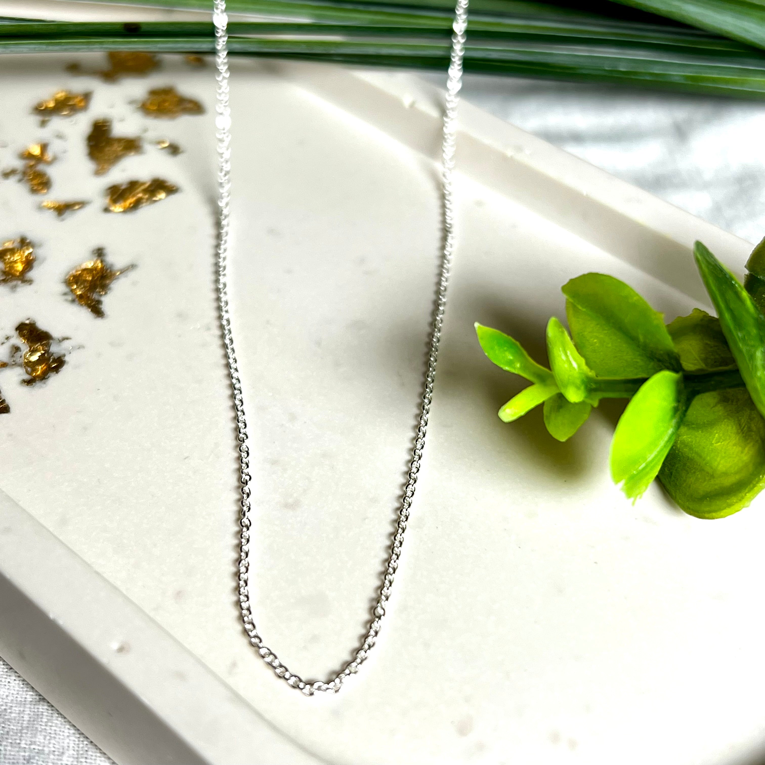 Zarte Ankerkette aus echtem 925 Silber mit klassischem Federring-Verschluss, 1 mm dick, 45 cm lang. Schlichtes, edles Design – ideal für Anhänger oder als feine Solokette. Stilvolle Schmuckfotografie mit natürlichem Hintergrund.