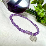 Handgefertigtes Amethyst-Armband aus facettierten 4 mm Edelstein-Perlen mit 925er Silber Charm „Blume des Lebens“. Spirituelles Schmuckstück in zartem Violett. Auf elastischem Gummiband, ca. 17 cm Innendurchmesser. Edles, fein gearbeitetes Design – ideal als Geschenk oder zur eigenen spirituellen Unterstützung.