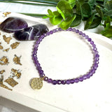 Handgefertigtes Amethyst-Armband mit facettierten 4 mm Edelstein-Perlen in zartem Violett, ergänzt durch einen vergoldeten 925 Silber Charm in Form der Blume des Lebens. Elastisches Design mit ca. 17 cm Innendurchmesser. Elegant, spirituell und fein – ein besonderes Schmuckstück für Achtsamkeit, Energie und Harmonie im Alltag.