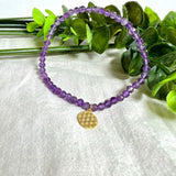 Handgefertigtes Amethyst-Armband mit facettierten 4 mm Edelstein-Perlen in zartem Violett, ergänzt durch einen vergoldeten 925 Silber Charm in Form der Blume des Lebens. Elastisches Design mit ca. 17 cm Innendurchmesser. Elegant, spirituell und fein – ein besonderes Schmuckstück für Achtsamkeit, Energie und Harmonie im Alltag.