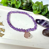 Handgefertigtes Amethyst-Armband mit facettierten 4 mm Perlen, kombiniert mit einem rosévergoldeten 925 Silber Charm in Form der Blume des Lebens. Auf elastischem Gummiband, Innendurchmesser ca. 17 cm. Edles spirituelles Design – harmonisch, zart & bedeutungsvoll. Perfekt als Geschenk oder für persönliche Achtsamkeitsmomente