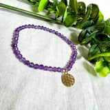 Handgefertigtes Amethyst-Armband mit facettierten 4 mm Edelstein-Perlen in zartem Violett, ergänzt durch einen vergoldeten 925 Silber Charm in Form der Blume des Lebens. Elastisches Design mit ca. 17 cm Innendurchmesser. Elegant, spirituell und fein – ein besonderes Schmuckstück für Achtsamkeit, Energie und Harmonie im Alltag.