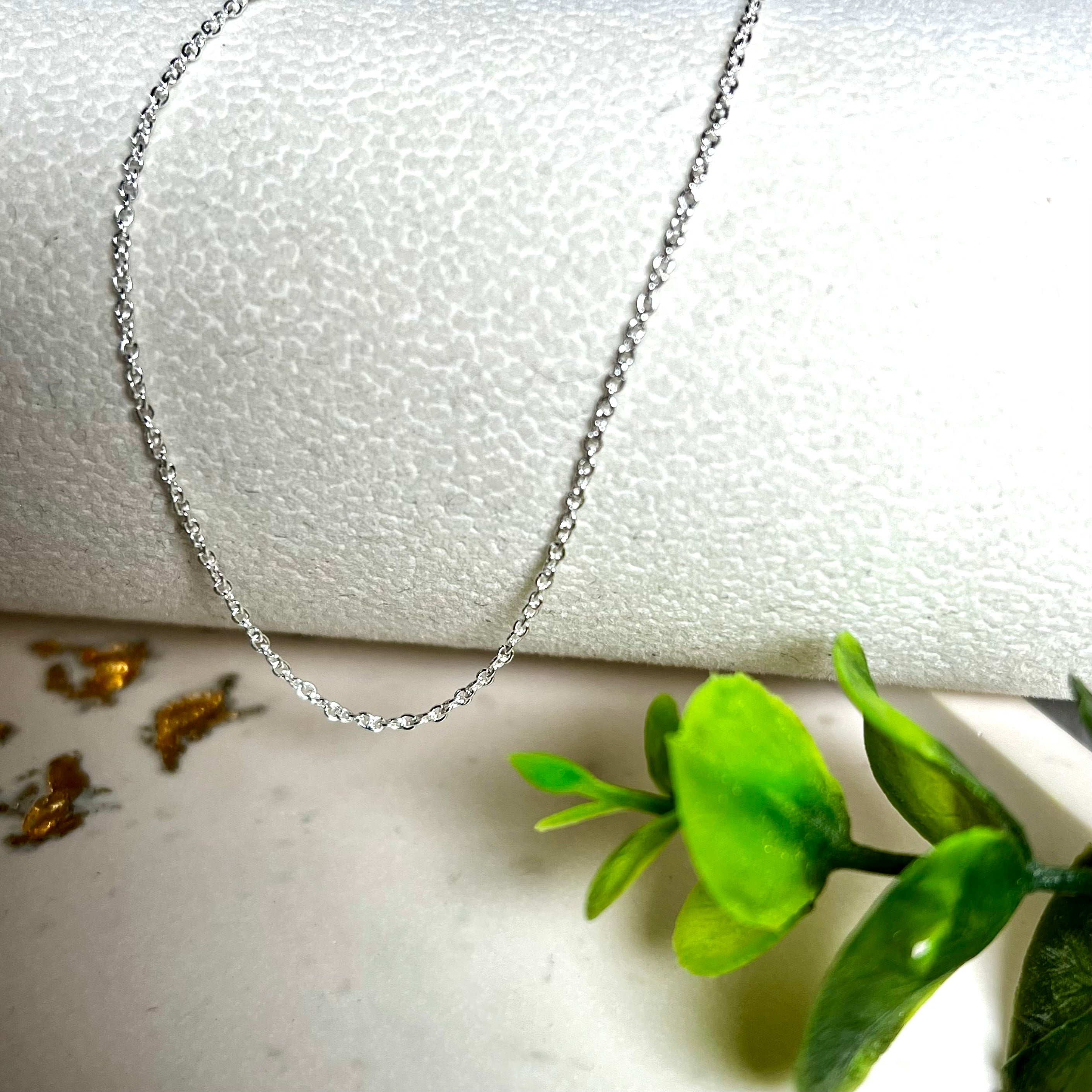 Zarte Ankerkette aus echtem 925 Silber mit klassischem Federring-Verschluss, 1 mm dick, 45 cm lang. Schlichtes, edles Design – ideal für Anhänger oder als feine Solokette. Stilvolle Schmuckfotografie mit natürlichem Hintergrund.