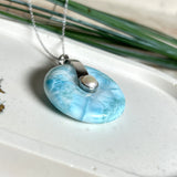 Echter Larimar-Donut (42 mm) mit Süßwasserperle, gefasst in rhodiniertem 925 Sterlingsilber. Mit 45 cm langer, rhodinierter Silberkette. Selten, edel & handgefertigt – inspiriert vom Blau der Karibik.