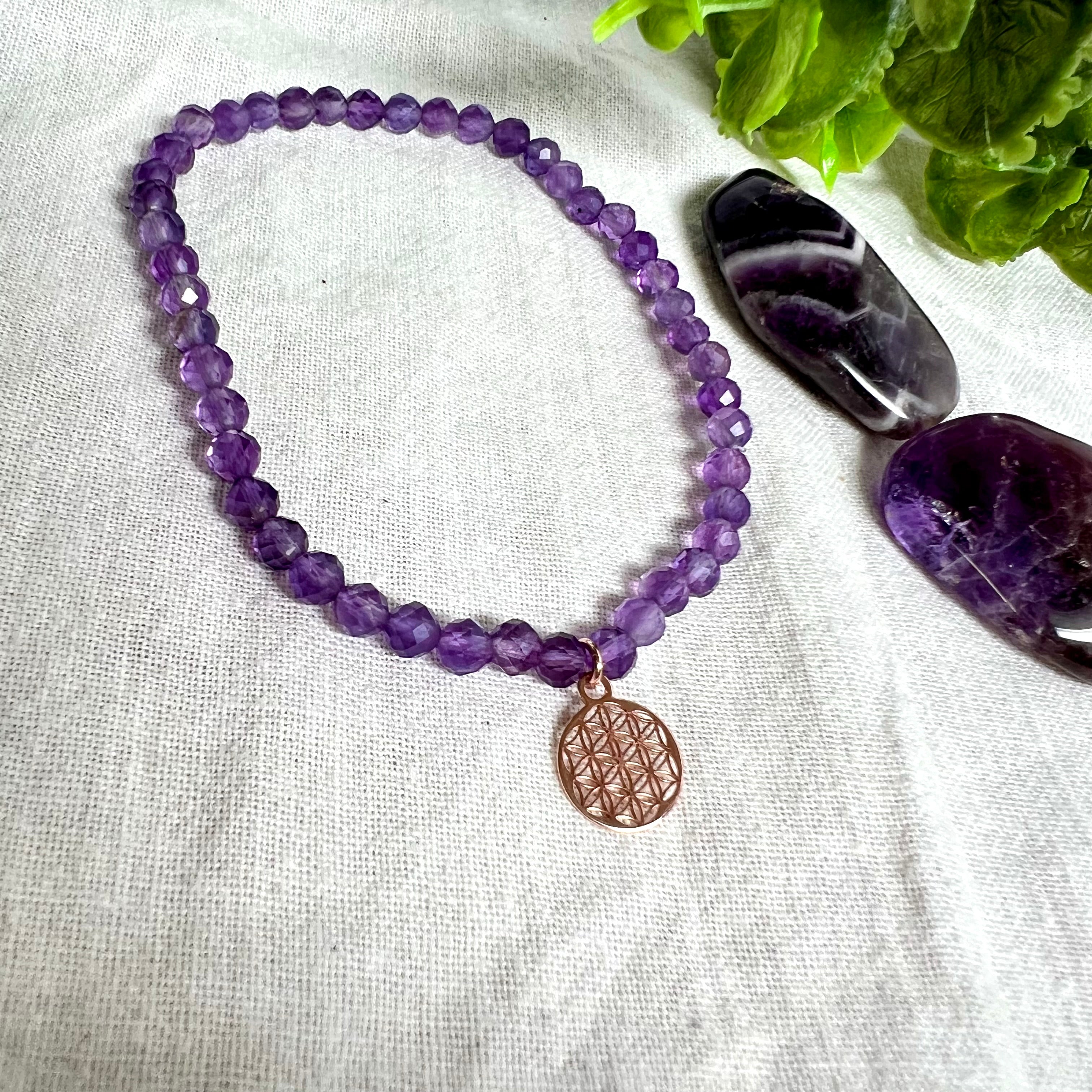 Handgefertigtes Amethyst-Armband mit facettierten 4 mm Perlen, kombiniert mit einem rosévergoldeten 925 Silber Charm in Form der Blume des Lebens. Auf elastischem Gummiband, Innendurchmesser ca. 17 cm. Edles spirituelles Design – harmonisch, zart & bedeutungsvoll. Perfekt als Geschenk oder für persönliche Achtsamkeitsmomente