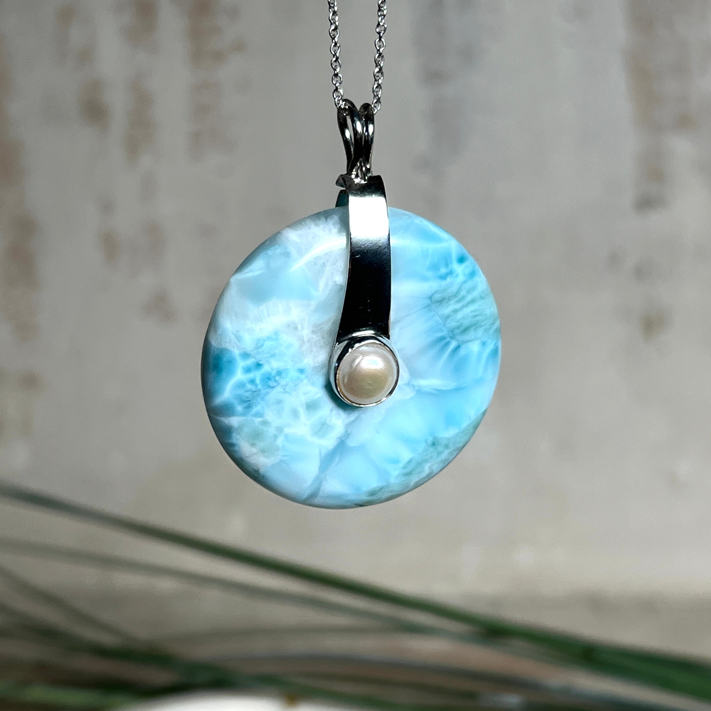 Echter Larimar-Donut (42 mm) mit Süßwasserperle, gefasst in rhodiniertem 925 Sterlingsilber. Mit 45 cm langer, rhodinierter Silberkette. Selten, edel & handgefertigt – inspiriert vom Blau der Karibik.