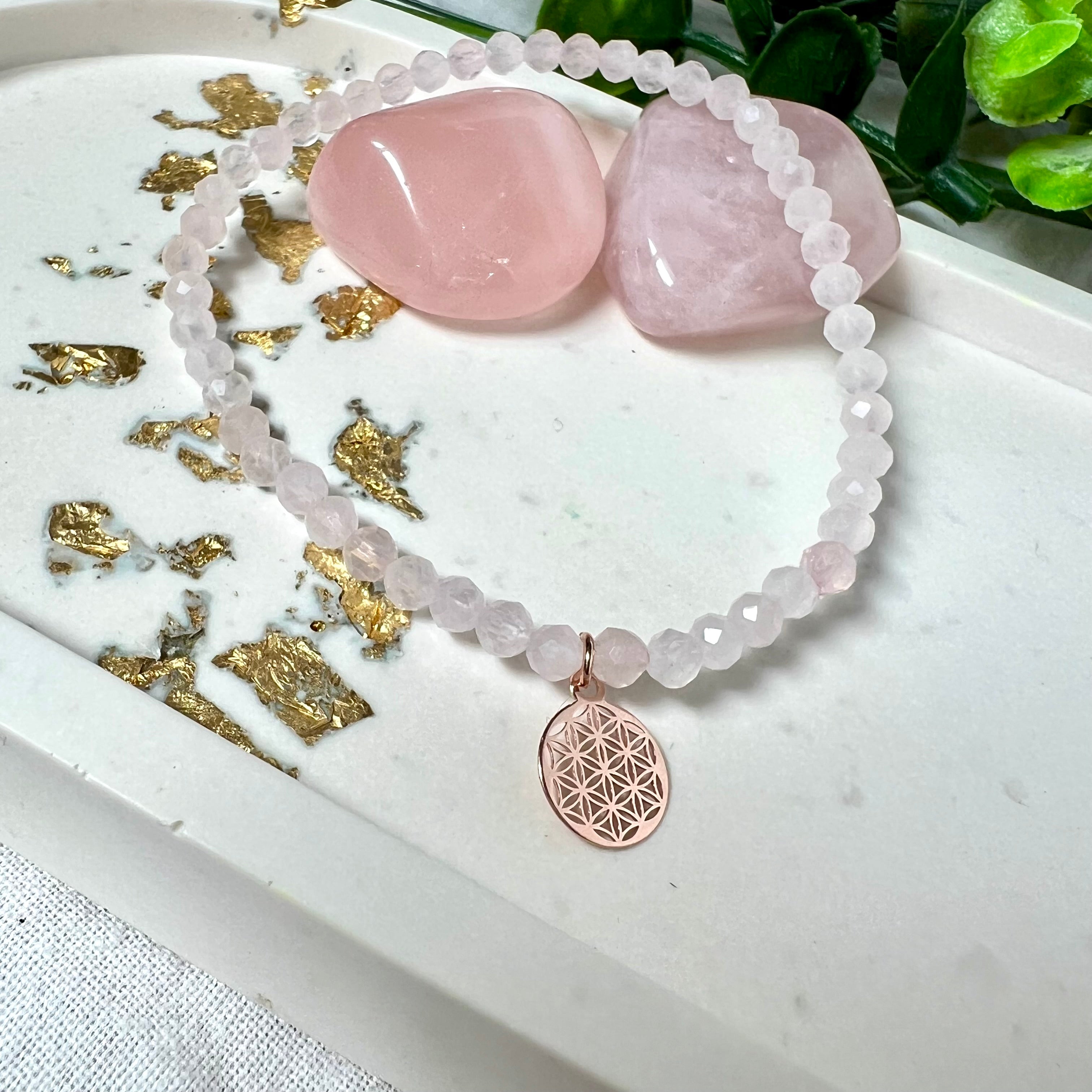 Handgefertigtes Rosenquarz-Armband mit facettierten 4 mm Perlen, ergänzt durch einen rosévergoldeten Blume des Lebens Charm aus 925er Silber. Auf elastischem Gummiband (Innendurchmesser ca. 17 cm) für bequemen Tragekomfort. Rosenquarz steht für Liebe, Harmonie und emotionale Heilung. Zartes, stilvolles Schmuckstück, ideal für den Alltag oder als besonderes Geschenk für Herzensmenschen.