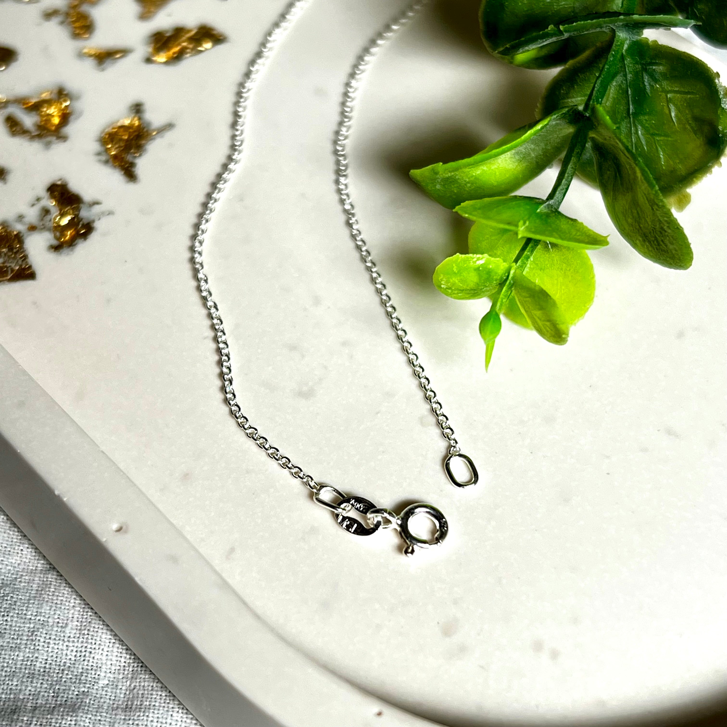 Zarte Ankerkette aus echtem 925 Silber mit klassischem Federring-Verschluss, 1 mm dick, 45 cm lang. Schlichtes, edles Design – ideal für Anhänger oder als feine Solokette. Stilvolle Schmuckfotografie mit natürlichem Hintergrund.