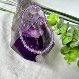 Handgefertigtes Amethyst-Armband aus facettierten 4 mm Edelstein-Perlen mit 925er Silber Charm „Blume des Lebens“. Spirituelles Schmuckstück in zartem Violett. Auf elastischem Gummiband, ca. 17 cm Innendurchmesser. Edles, fein gearbeitetes Design – ideal als Geschenk oder zur eigenen spirituellen Unterstützung.