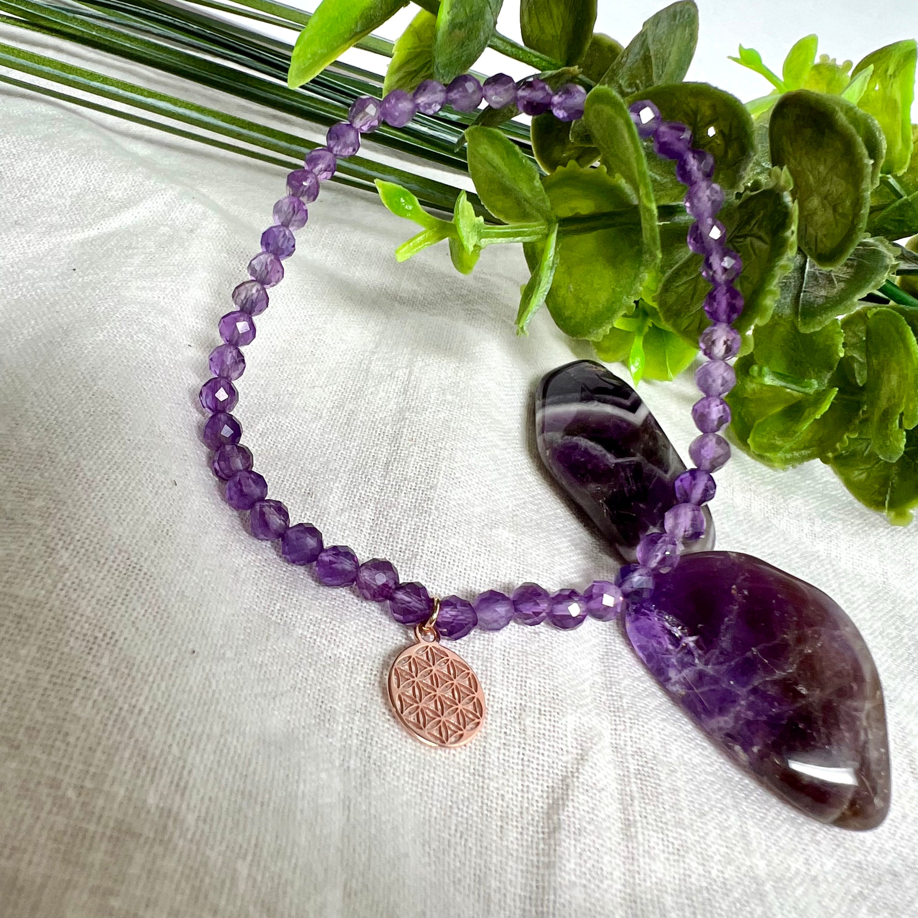 Handgefertigtes Amethyst-Armband mit facettierten 4 mm Perlen, kombiniert mit einem rosévergoldeten 925 Silber Charm in Form der Blume des Lebens. Auf elastischem Gummiband, Innendurchmesser ca. 17 cm. Edles spirituelles Design – harmonisch, zart & bedeutungsvoll. Perfekt als Geschenk oder für persönliche Achtsamkeitsmomente