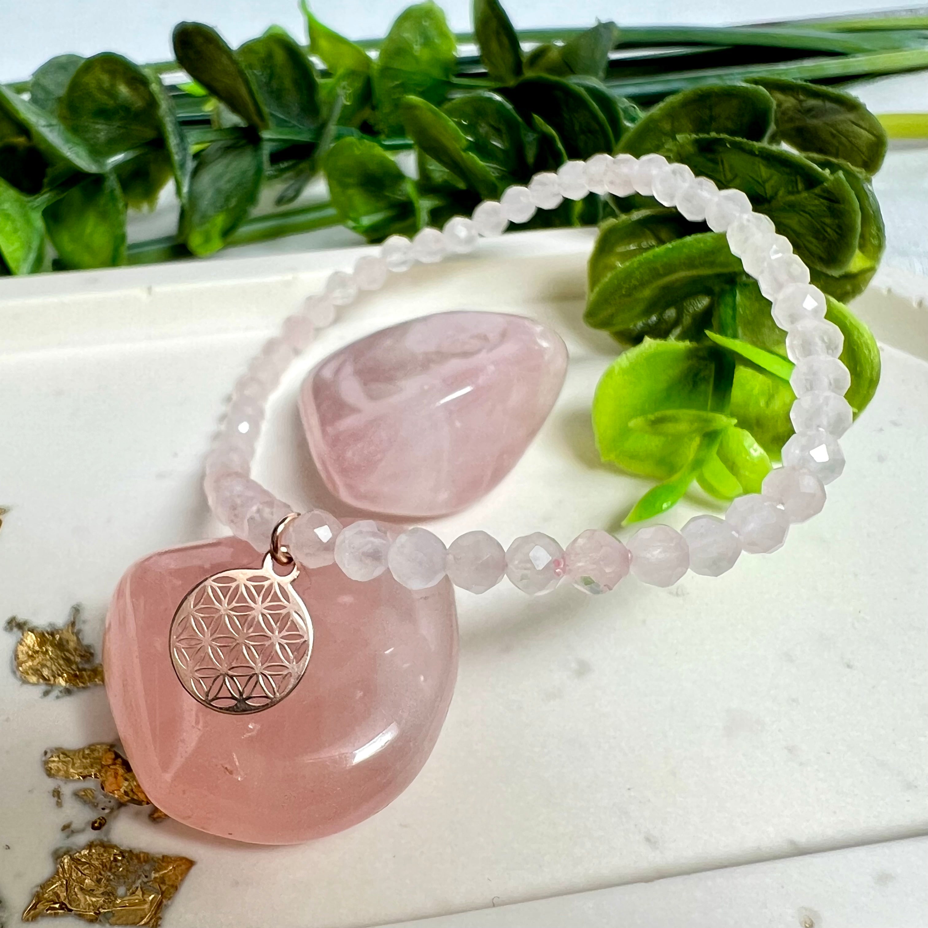 Handgefertigtes Rosenquarz-Armband mit facettierten 4 mm Perlen, ergänzt durch einen rosévergoldeten Blume des Lebens Charm aus 925er Silber. Auf elastischem Gummiband (Innendurchmesser ca. 17 cm) für bequemen Tragekomfort. Rosenquarz steht für Liebe, Harmonie und emotionale Heilung. Zartes, stilvolles Schmuckstück, ideal für den Alltag oder als besonderes Geschenk für Herzensmenschen.