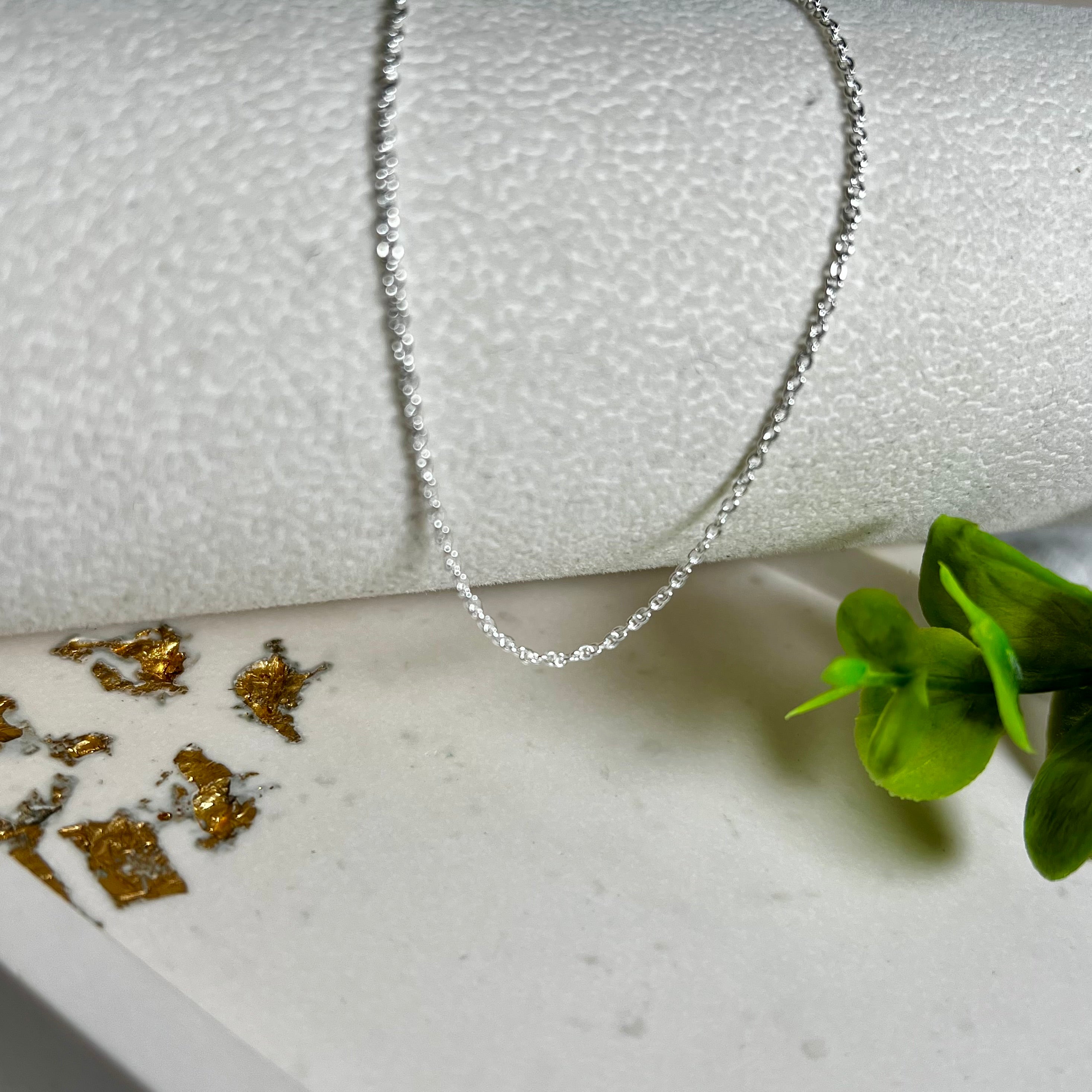 Zarte Ankerkette aus echtem 925 Silber mit klassischem Federring-Verschluss, 1 mm dick, 45 cm lang. Schlichtes, edles Design – ideal für Anhänger oder als feine Solokette. Stilvolle Schmuckfotografie mit natürlichem Hintergrund.