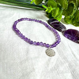 Handgefertigtes Amethyst-Armband aus facettierten 4 mm Edelstein-Perlen mit 925er Silber Charm „Blume des Lebens“. Spirituelles Schmuckstück in zartem Violett. Auf elastischem Gummiband, ca. 17 cm Innendurchmesser. Edles, fein gearbeitetes Design – ideal als Geschenk oder zur eigenen spirituellen Unterstützung.