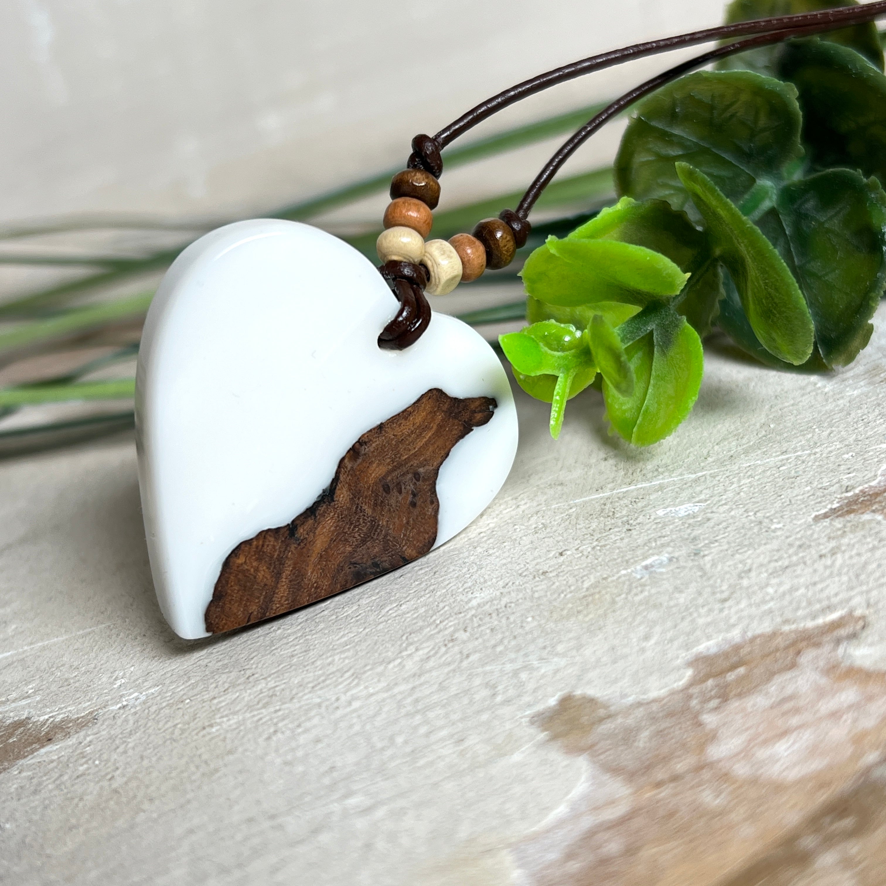 Herzanhänger „Pure Heart“ aus Maserholz und weißem Epoxidharz. Handgefertigtes Unikat mit kontrastreichem Design – die natürliche Maserung des Holzes trifft auf die klare Reinheit von Weiß. Größe ca. 3,5 × 3,5 cm. Verstellbares Lederband (23–41 cm) mit Holzperlen. Ein edles Schmuckstück, inspiriert von Natur und Liebe.