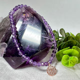 Handgefertigtes Amethyst-Armband mit facettierten 4 mm Perlen, kombiniert mit einem rosévergoldeten 925 Silber Charm in Form der Blume des Lebens. Auf elastischem Gummiband, Innendurchmesser ca. 17 cm. Edles spirituelles Design – harmonisch, zart & bedeutungsvoll. Perfekt als Geschenk oder für persönliche Achtsamkeitsmomente
