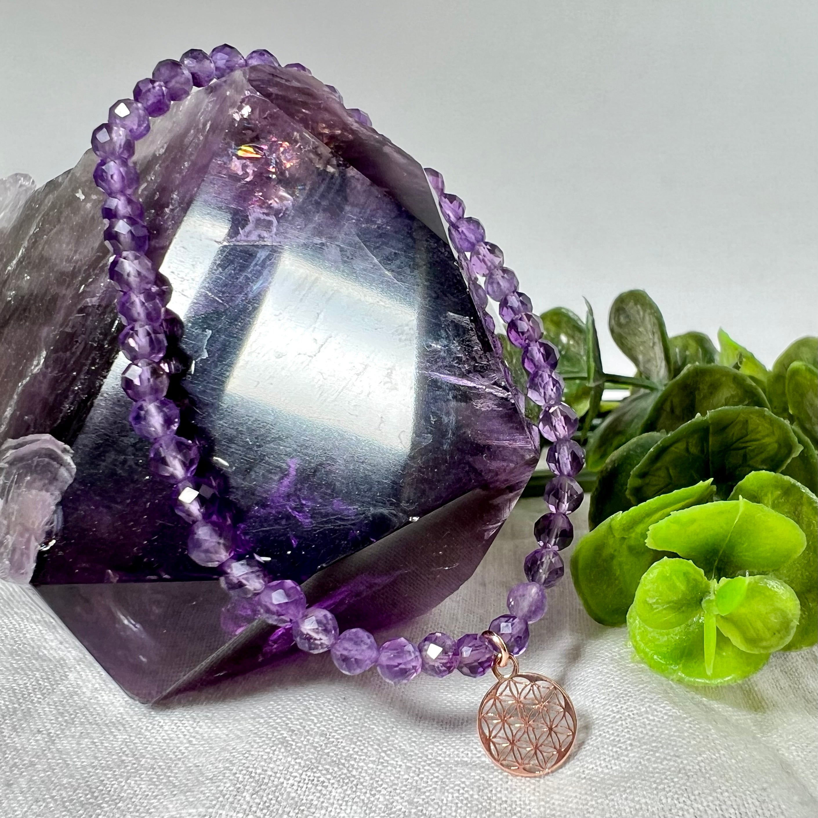 Handgefertigtes Amethyst-Armband mit facettierten 4 mm Perlen, kombiniert mit einem rosévergoldeten 925 Silber Charm in Form der Blume des Lebens. Auf elastischem Gummiband, Innendurchmesser ca. 17 cm. Edles spirituelles Design – harmonisch, zart & bedeutungsvoll. Perfekt als Geschenk oder für persönliche Achtsamkeitsmomente