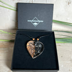 „Handgefertigter Herzanhänger aus Olivenholz und klarem Harz mit echter Pusteblume. Der Anhänger (ca. 3,5 × 3,5 cm) hängt an einem verstellbaren Lederband (23–43 cm) mit Holzperlen. Symbol für Wünsche und Glück, sorgfältig in Handarbeit gegossen, gesägt, geschliffen und poliert. Ein einzigartiger, naturinspirierter Anhänger – ideal als Geschenk oder persönlicher Talisman.“