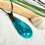 Tropfen Anhänger aus dunklem Maserholz und Epoxidharz in Türkis Blau mit weißer Wellenstruktur am schwarzen Lederband, maritimer Holz Harz Naturschmuck