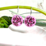 Handgemachte Leo-Creolen aus 925 Silber: Silber-Creolen 16 mm mit rosa Harz-Scheibe (2 cm) im Leoparden-Look und Edelstahl-Herzanhänger. Hängende Ohrringe in Animal-Print Stil, Gesamtlänge ca. 3,5 cm. Resin-Ohrringe für Alltag, Party oder Festival, femininer Statement-Schmuck in Rosa/Pink mit silberfarbenen Metallteilen. Einzeln gegossen, jedes Paar ein Unikat; leichte Abweichungen im Muster, Farbspiel und kleine Luftbläschen sind möglich und typisch für Handarbeit.