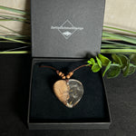 Handgefertigter Herzanhänger aus Olivenholz und klarem Harz mit echten Pusteblumen. Der Anhänger misst ca. 3,5 cm, das Lederband ist verstellbar von 23–43 cm und mit kleinen Holzperlen verziert. Ein natürliches Unikat, Symbol für Wünsche und Glück – sorgfältig gegossen, gesägt, geschliffen und poliert.