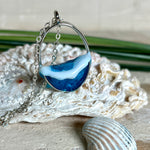 Ovale Halskette „Ocean Crest“ mit 3D-Welle: handgefertigter Harz-Anhänger in Silber-Legierung, Farbverlauf von Tiefblau zu Türkis mit weißer Schaumkrone. Größe ca. 3,9 × 2,3 cm, an einer ca. 56 cm langen versilberten Kette. Glänzende Oberfläche, maritimer Look, Unikat-Handarbeit.