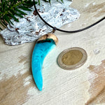 Handgefertigter Anhänger aus Edelholz und transparent-türkisblauem und weißen Epoxidharz, glatt poliert. Größe ca. 6,5 × 2,0 cm. Mit Edelstahlöse an schwarzer Lederkette (45 cm + 5 cm Edelstahl-Verlängerung, Karabiner). Moderner, unisex tragbarer Schmuck mit natürlicher Holzmaserung; kleine Lufteinschlüsse sind charakteristisch.