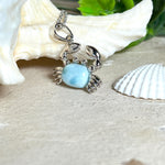 Krabben-Anhänger „Crab of Light“ aus rhodiniertem 925 Sterling Silber mit seltenem Larimar Edelstein aus der Dominikanischen Republik. Der Anhänger (28 × 18 mm) wird mit einer feinen 45 cm langen Silberkette geliefert. Symbol für Schutz, Intuition und die Kraft des Meeres – jedes Schmuckstück ein Unikat durch das natürliche Farbspiel des Larimars.