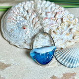 Ovale Halskette „Ocean Crest“ mit 3D-Welle: handgefertigter Harz-Anhänger in Silber-Legierung, Farbverlauf von Tiefblau zu Türkis mit weißer Schaumkrone. Größe ca. 3,9 × 2,3 cm, an einer ca. 56 cm langen versilberten Kette. Glänzende Oberfläche, maritimer Look, Unikat-Handarbeit.