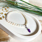 Handgefertigtes Armband „Sea Harmony“ mit schimmernden Süßwasserperlen (Ø ca. 6–7 mm), jede Perle ein Unikat. Auf elastischem Band gefädelt, mit einem filigranen Charmanhänger aus  Amethyst-Perlen, befestigt an einem robusten Edelstahl-Karabiner. Ein Schmuckstück voller Eleganz, maritimer Harmonie und symbolischer Tiefe – ideal als Geschenk oder als stilvolles Accessoire.