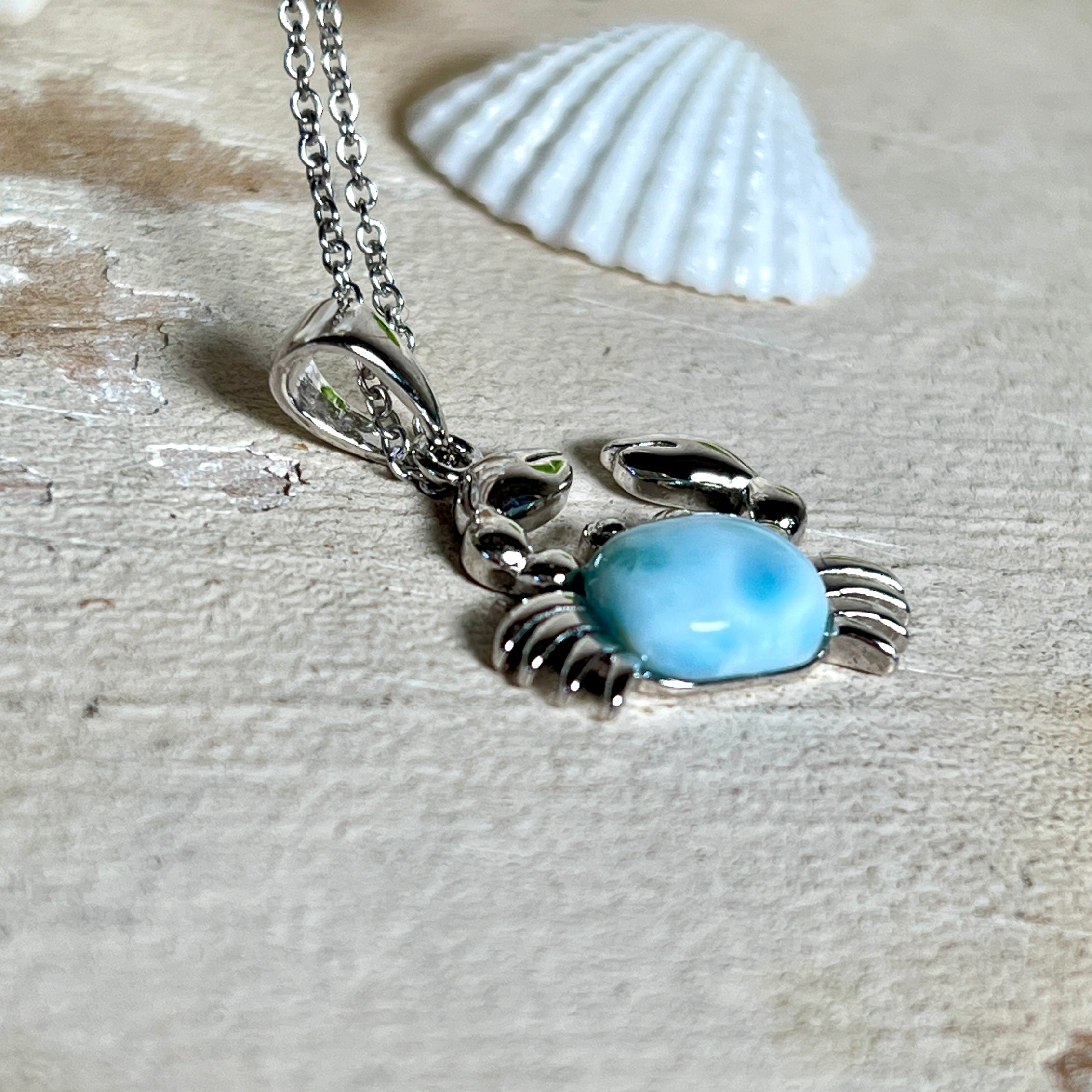 Krabben-Anhänger „Crab of Light“ aus rhodiniertem 925 Sterling Silber mit seltenem Larimar Edelstein aus der Dominikanischen Republik. Der Anhänger (28 × 18 mm) wird mit einer feinen 45 cm langen Silberkette geliefert. Symbol für Schutz, Intuition und die Kraft des Meeres – jedes Schmuckstück ein Unikat durch das natürliche Farbspiel des Larimars.