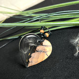 „Handgefertigter Herzanhänger aus Olivenholz und klarem Harz mit echter Pusteblume. Der Anhänger (ca. 3,5 × 3,5 cm) hängt an einem verstellbaren Lederband (23–43 cm) mit Holzperlen. Symbol für Wünsche und Glück, sorgfältig in Handarbeit gegossen, gesägt, geschliffen und poliert. Ein einzigartiger, naturinspirierter Anhänger – ideal als Geschenk oder persönlicher Talisman.“