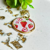 „Handgefertigter Erdbeer Anhänger aus Resin mit zarten Erdbeermotiven, gefasst in 24K vergoldet , glänzender Lünette – sommerlicher Handmade Schmuck und liebevolle Geschenkidee für Frauen und Naturfreunde“