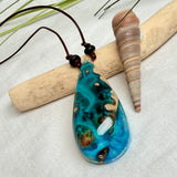Holz-Harz-Anhänger aus Maserholz mit türkis-blauem Epoxidharz in Tropfenform am verstellbaren Lederband mit Onyxperlen, handgemachter maritimer Naturschmuck