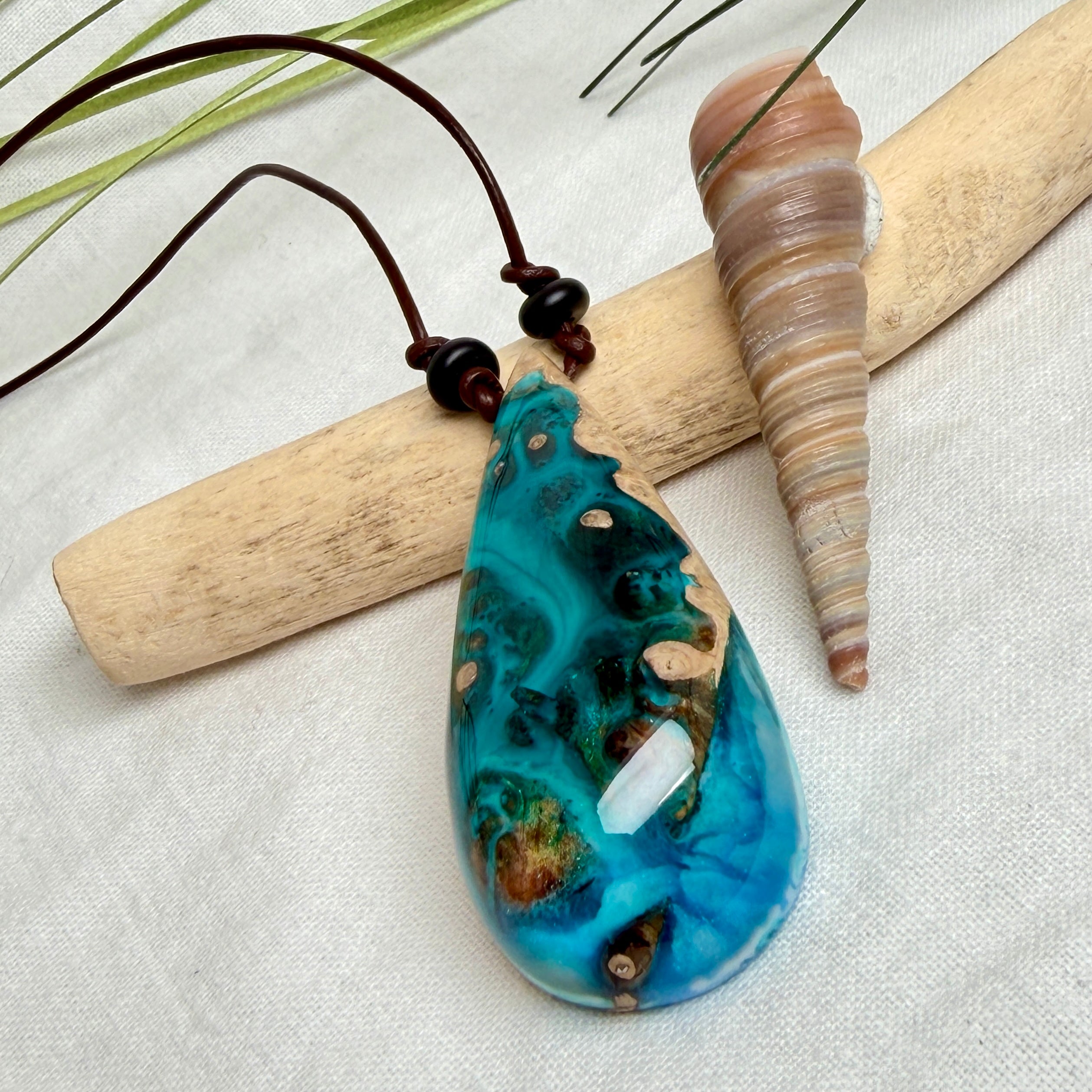 Holz-Harz-Anhänger aus Maserholz mit türkis-blauem Epoxidharz in Tropfenform am verstellbaren Lederband mit Onyxperlen, handgemachter maritimer Naturschmuck