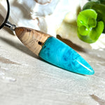 Anhänger aus Eibenholz und Epoxidharz in Blau-Türkis, Weiß und Transparent. Größe ca. 5,8 × 2 cm, Edelstahlöse, Lederkette 45+5 cm. Handgefertigtes Unikat inspiriert vom Ozean.