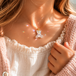 KI-Tragebild SCHIMMERBÄR – moderner Bärchen Anhänger aus klarem Resin mit irisierenden Flakes und goldfarbener Edelstahlschlaufe, glitzernder Mini-Charm ohne Kette als Geschenkidee für Mädchen.