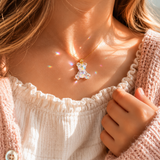 KI-Tragebild SCHIMMERBÄR – moderner Bärchen Anhänger aus klarem Resin mit irisierenden Flakes und goldfarbener Edelstahlschlaufe, glitzernder Mini-Charm ohne Kette als Geschenkidee für Mädchen.