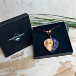 Handgemachter Herzanhänger aus Eibenholz mit lila Harz und Paua-Muschel-Inlay an braunem, verstellbarem Lederband.